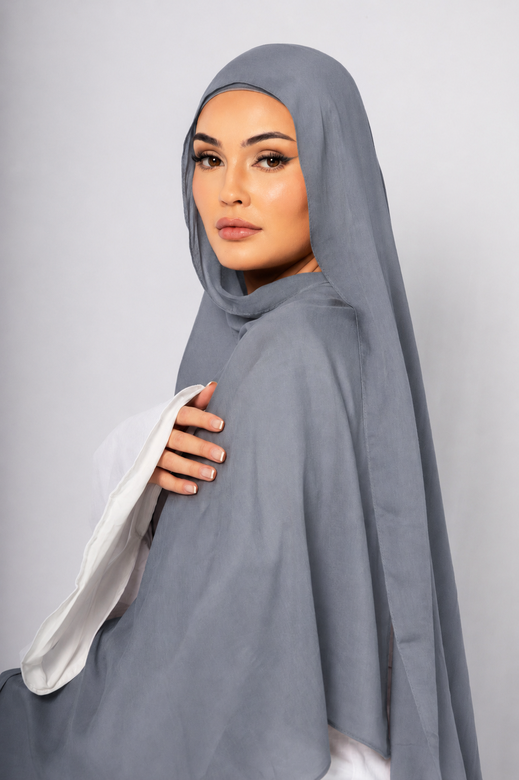 Side profile of a woman wearing the Blue Haze modal hijab in a soft light blue shade, highlighting the smooth drape, breathable fabric, and elegant modest style.