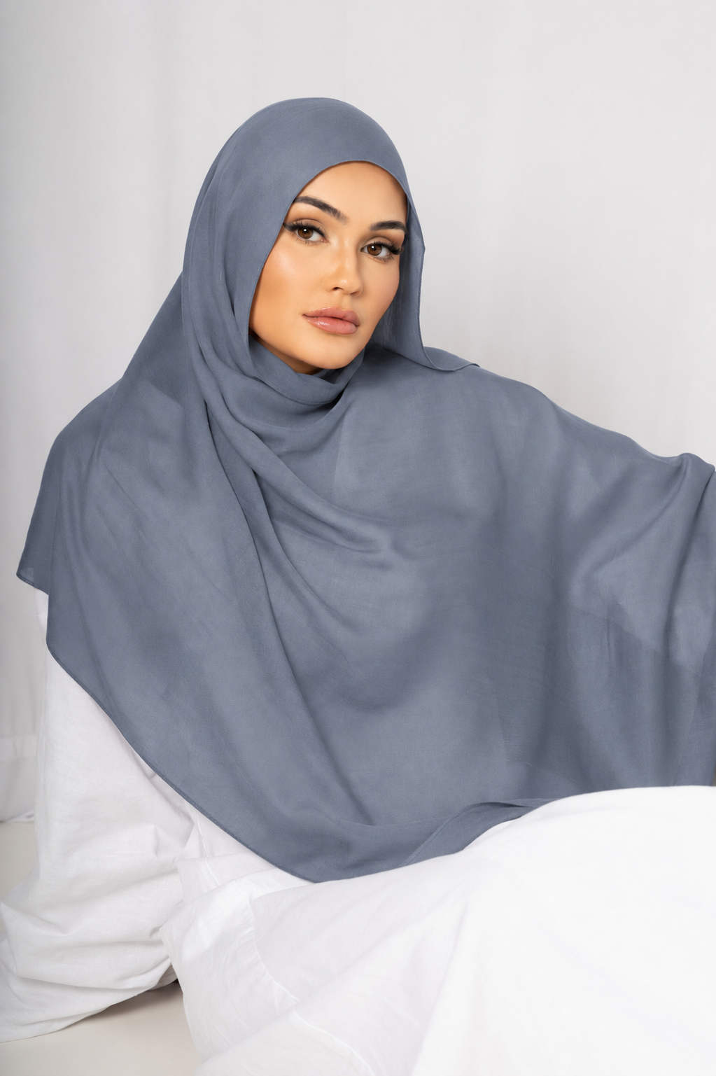 Woman wearing the Blue Haze modal hijab in a soft light blue shade with a lightweight draped finish, styled for modest everyday and formal wear
