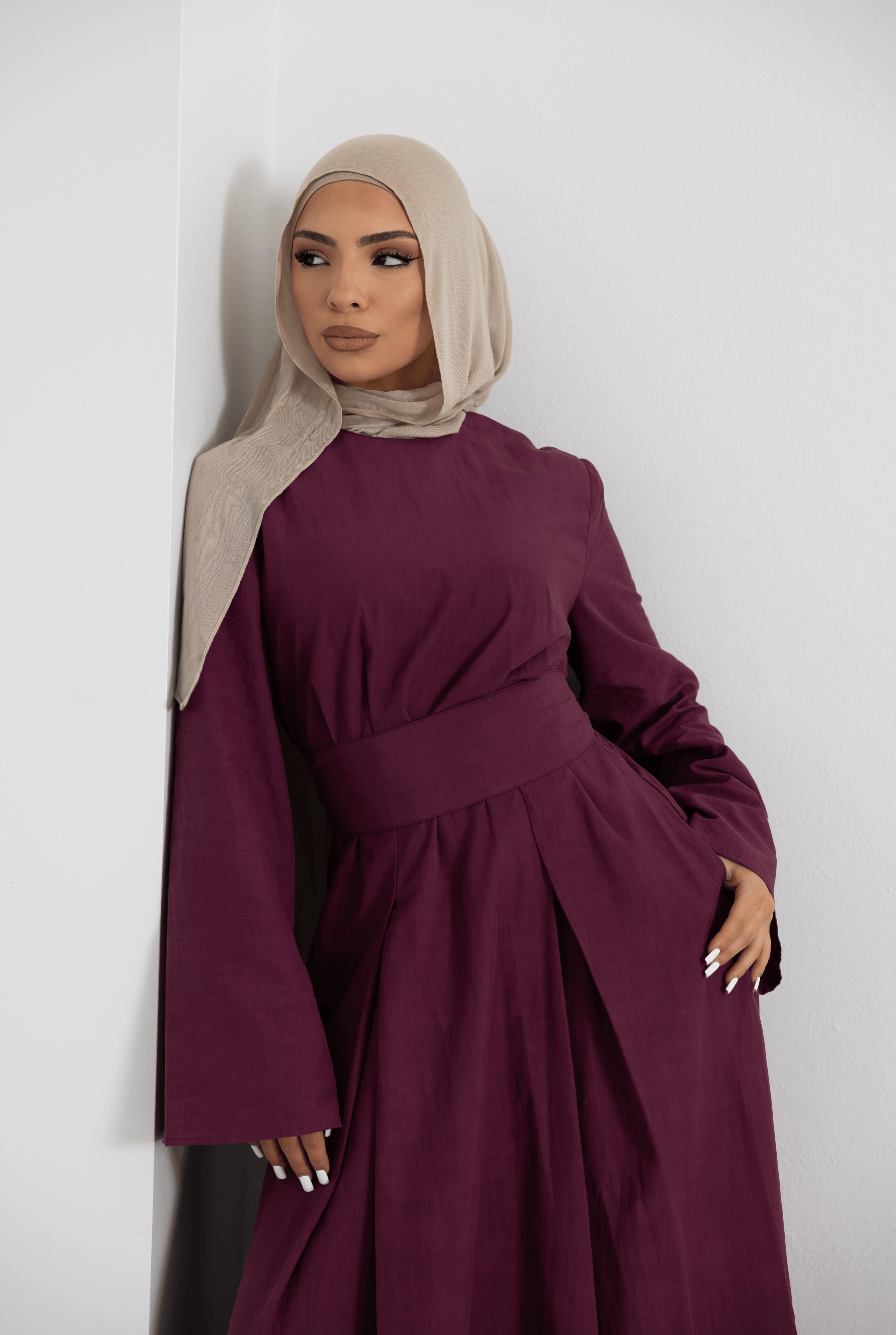 Close-up view of the Sorelle Belted Dress in plum, showcasing the elegant wide waist belt, flowing full-length silhouette, and long sleeves. Crafted from a breathable lyocell-linen blend, this modest maxi dress offers timeless style, comfort, and effortless sophistication.