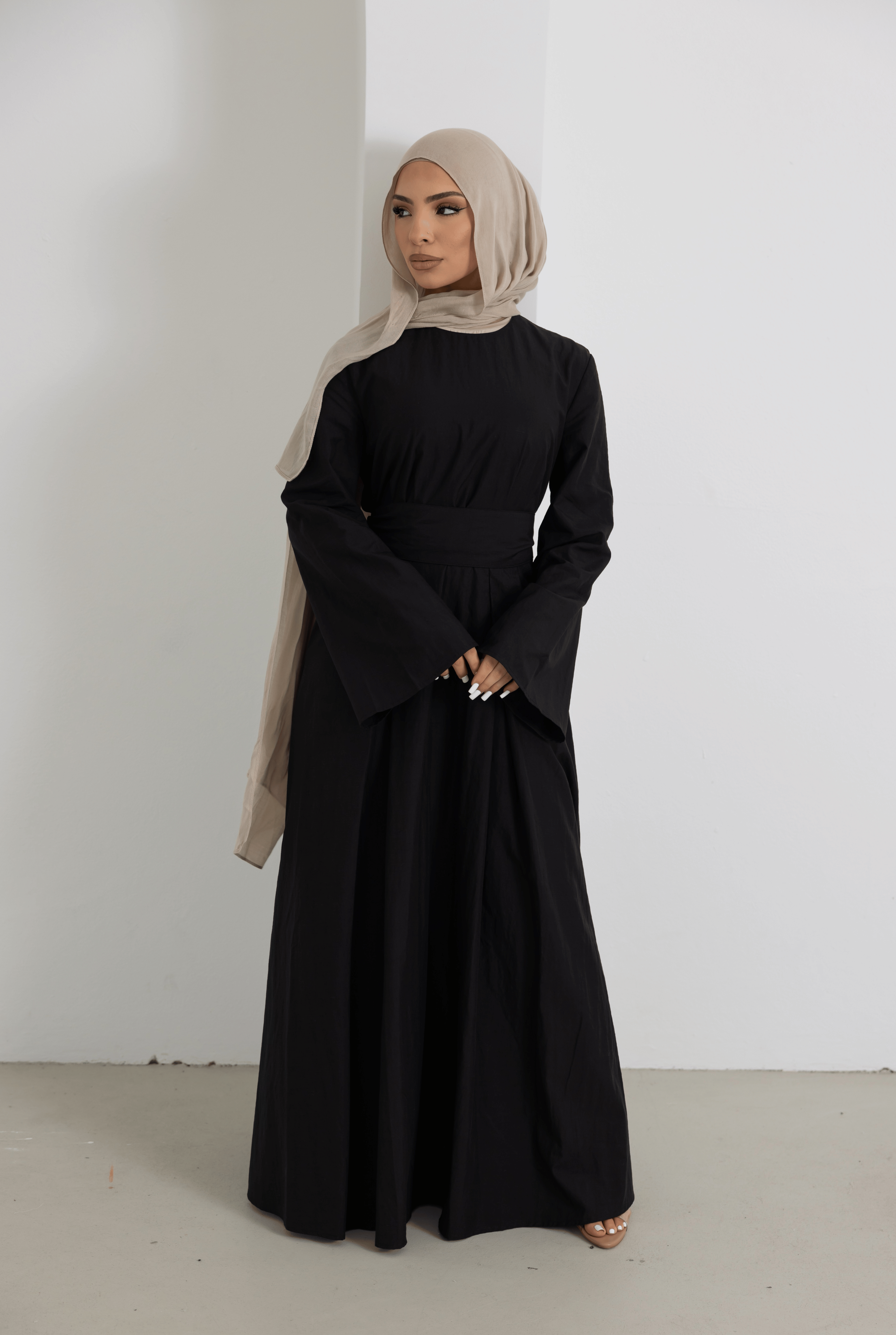 Front view of the Sorelle Belted Dress in black, featuring a full-length modest silhouette, wide sleeves, a matching waist belt, and a soft breathable lyocell-linen blend for elegant everyday wear.