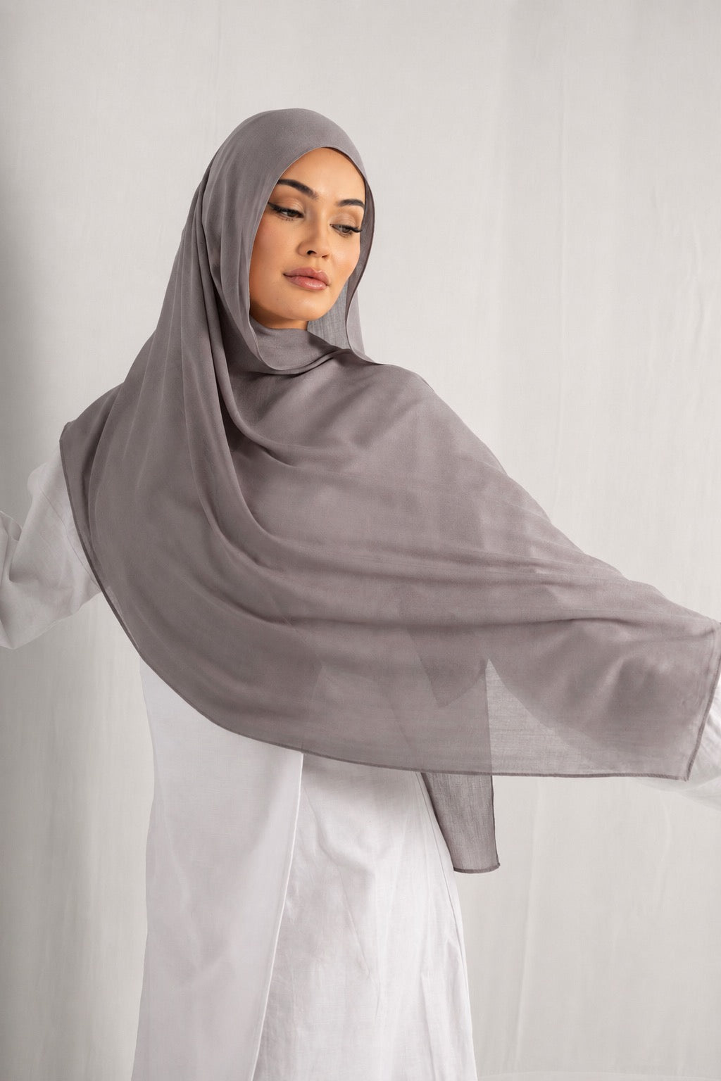 Woman wearing the Ash Taupe modal hijab, showcasing the lightweight fabric, flowing drape, and elegant modest style in a soft taupe shade