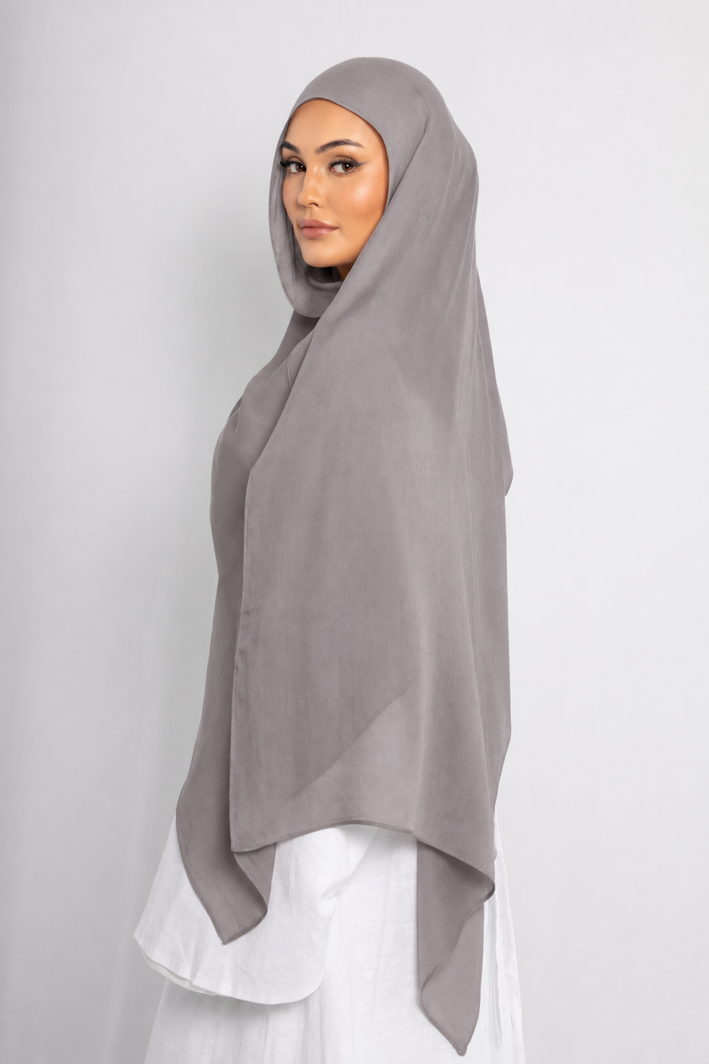 Side view of a woman wearing the Ash Taupe modal hijab, showcasing the soft taupe colour, lightweight breathable fabric, and elegant full-length drape