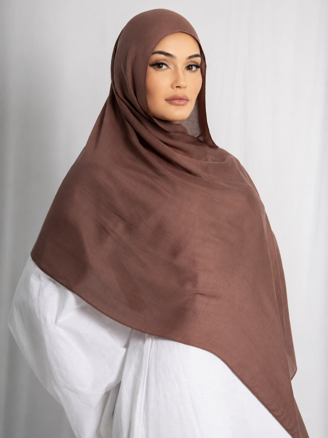 Front view of a model wearing the Cinnamon modal hijab, featuring a warm cinnamon brown shade, lightweight breathable fabric, and an elegant drape for modest everyday styling