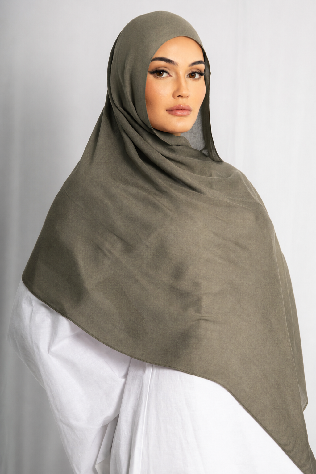 Model wearing the Olive Grove modal hijab in a front view, featuring its earthy olive green color, lightweight breathable modal fabric, soft drape, and elegant modest silhouette