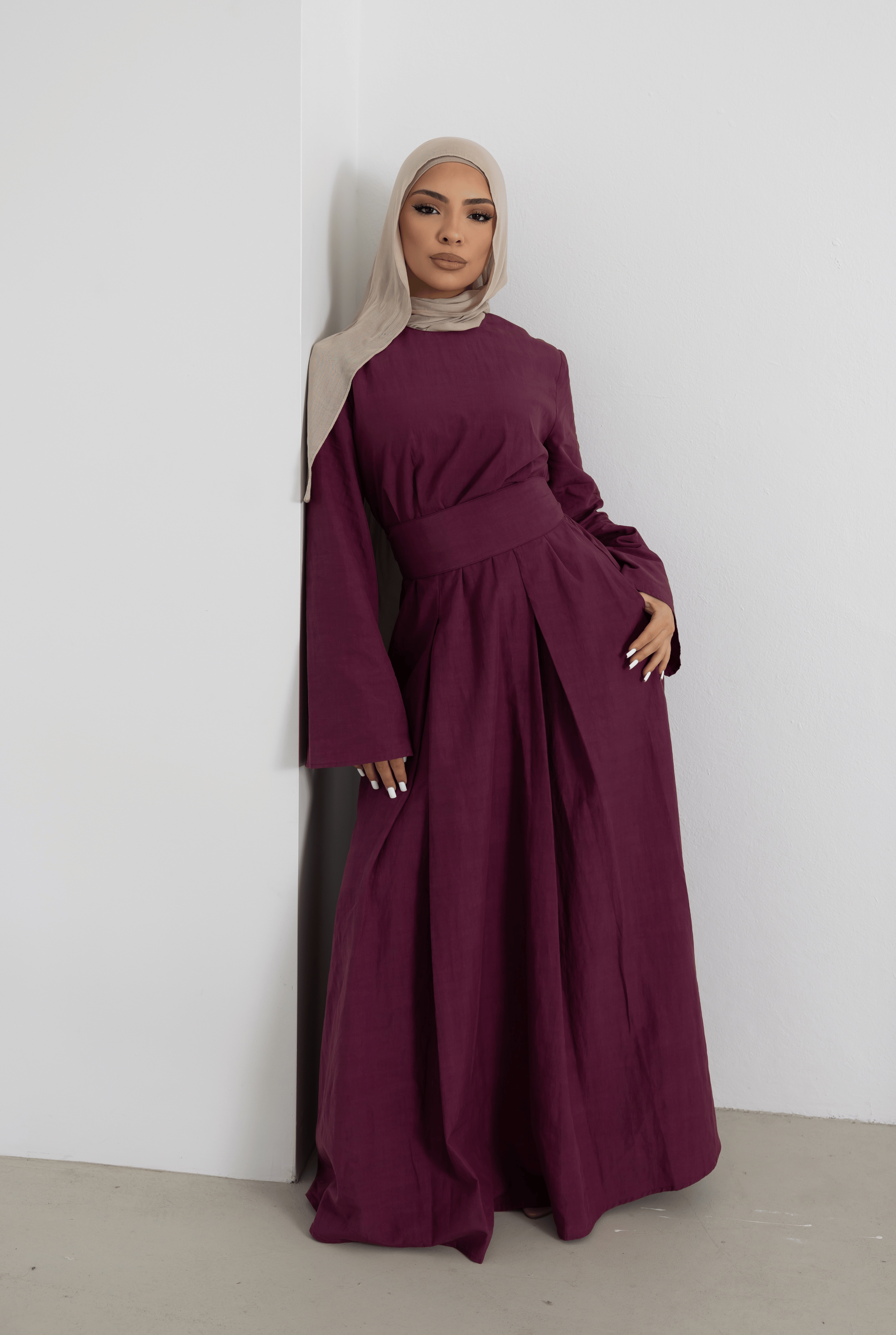 Front view of the Sorelle Belted Dress in plum, featuring a full-length modest silhouette, matching wide waist belt, and elegant wide sleeves. Crafted from a breathable lyocell-linen blend, this timeless dress offers graceful movement, comfort, and sophisticated styling for everyday wear and special occasions.