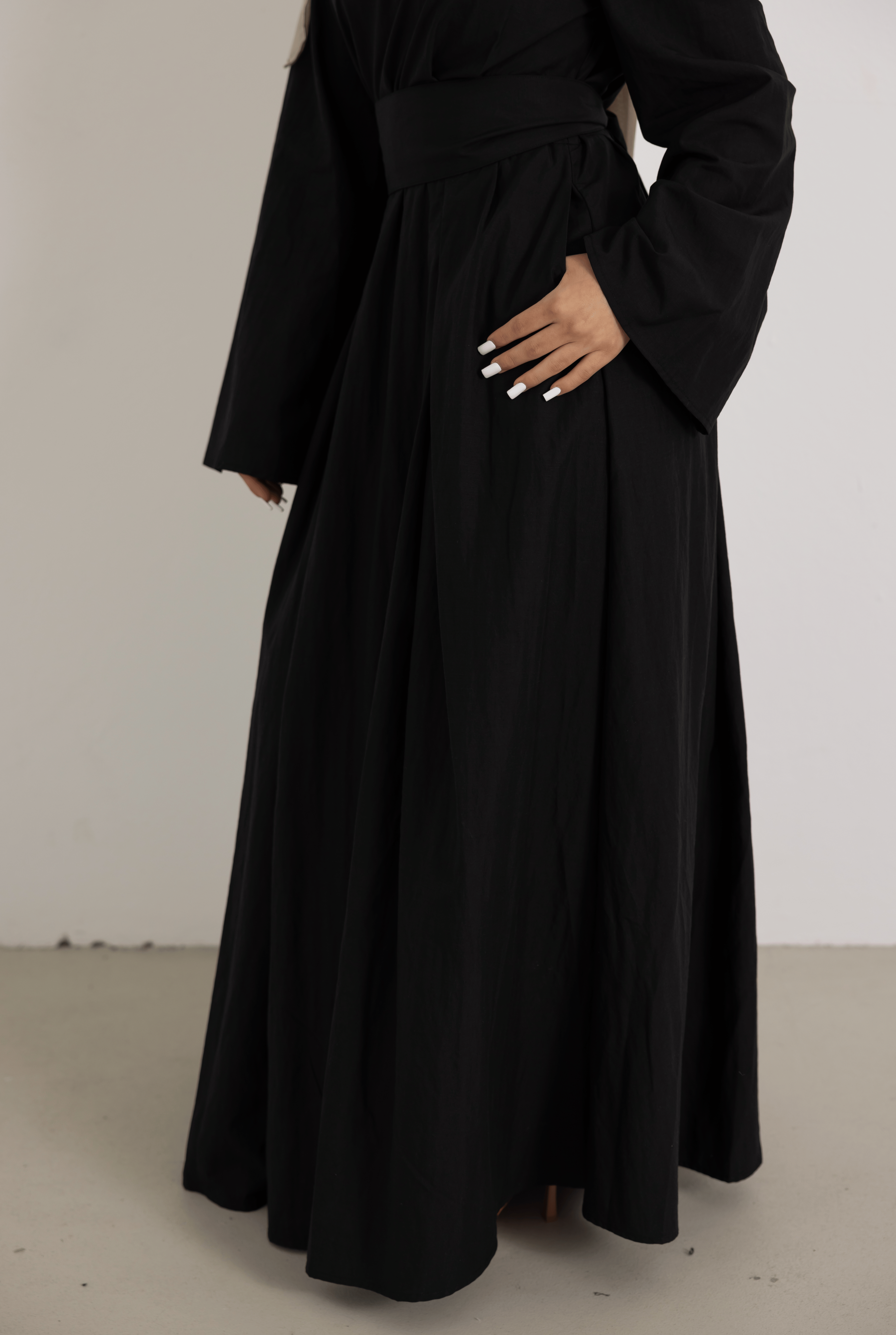 Close-up detail of the Sorelle Belted Dress in black, showcasing the wide waist belt, elegant draping, and flowing lyocell-linen fabric. A modest full-length dress designed for comfort, sophistication, and effortless everyday wear.