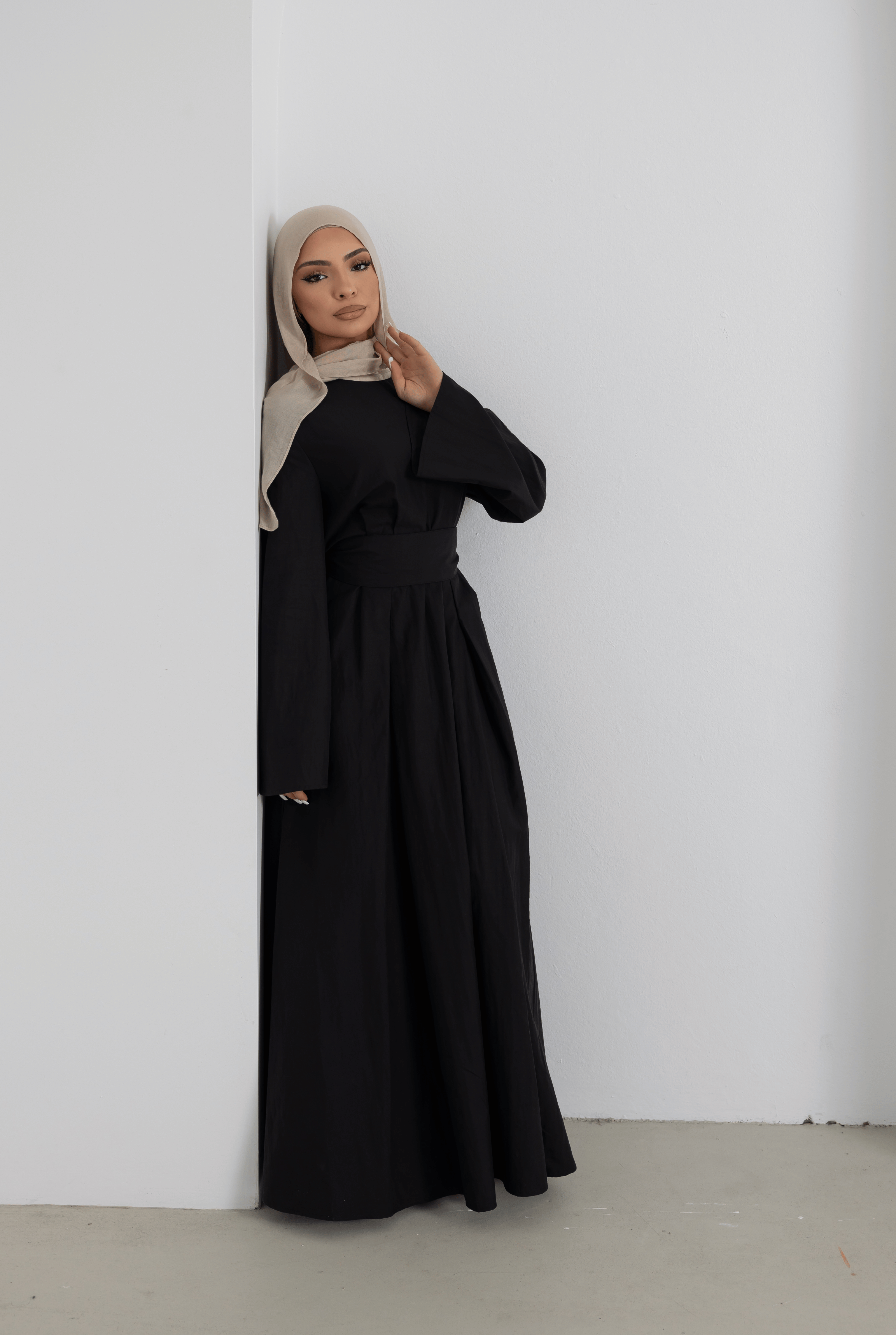Elegant portrait of the Sorelle Belted Dress in black, featuring a flowing full-length silhouette, wide waist belt, and graceful long sleeves. Crafted from a breathable lyocell-linen blend, this modest maxi dress offers timeless sophistication, comfort, and effortless everyday elegance.